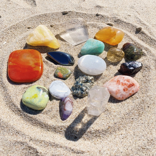 An assortment of various crystal displayed on the sand